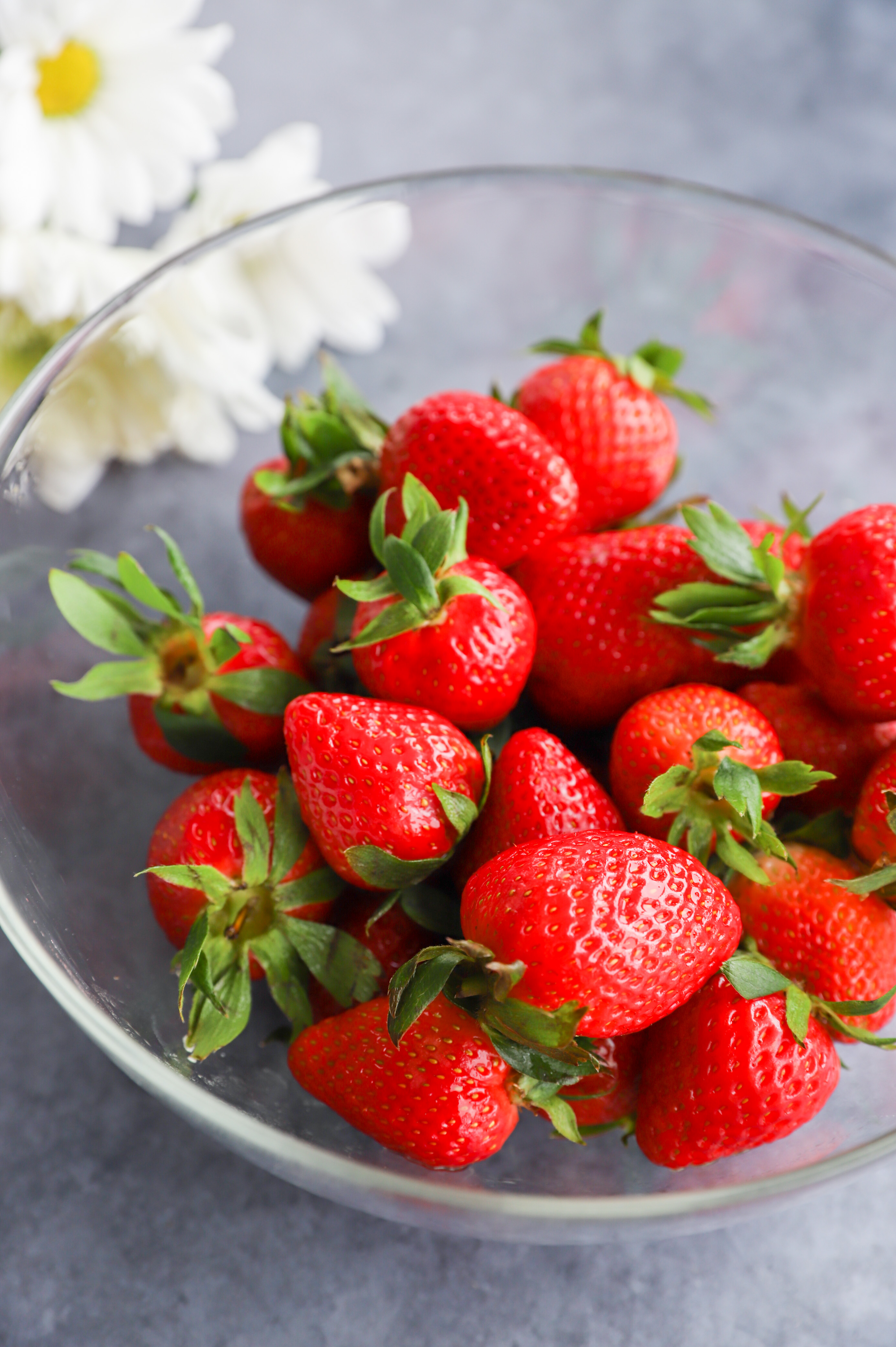 fresh strawberries in a bowl with flowers image