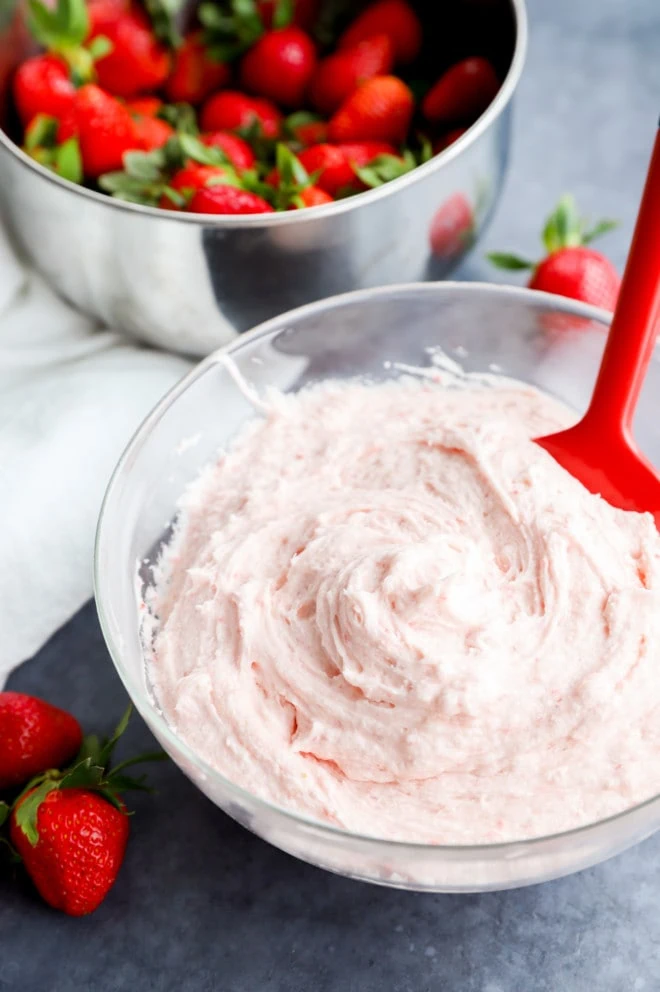 fresh berry cake decoration in a bowl with a spatula and fresh fruit