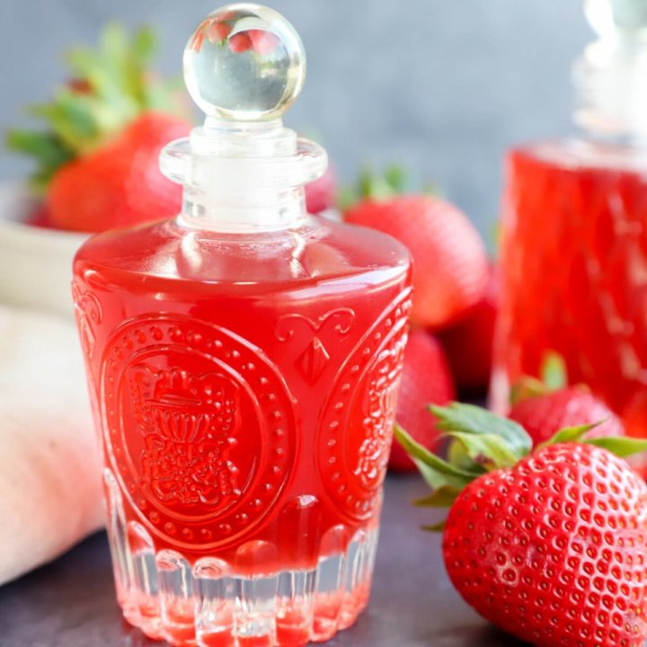 strawberry simple syrup in bottles with fresh berries image