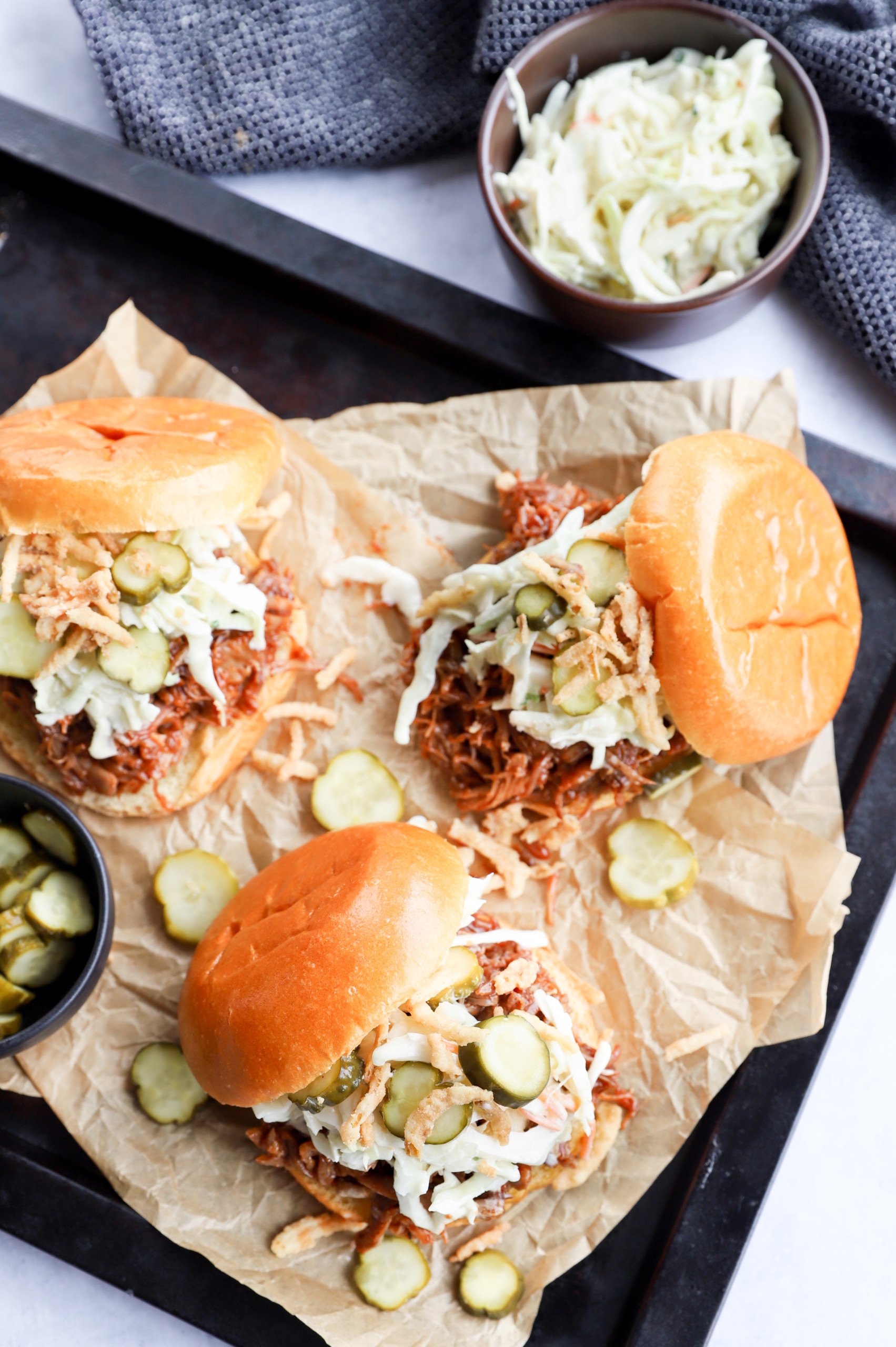 Overhead image of pulled pork burgers on pan