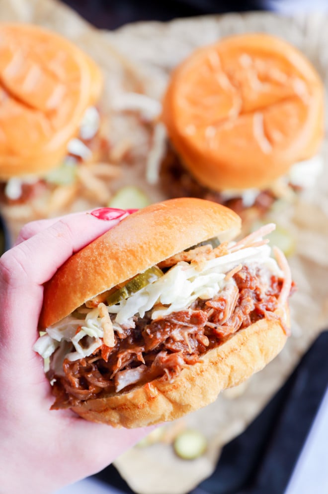 Hand holding a pulled pork burger image