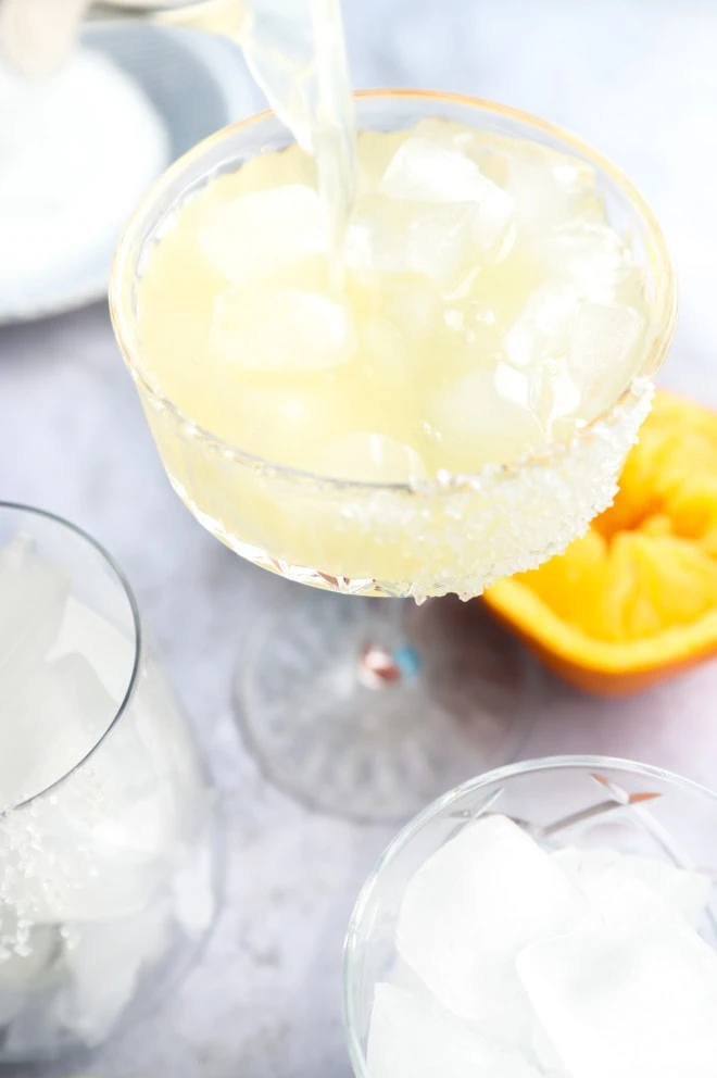 Pouring texas margarita into a glass filled with ice image