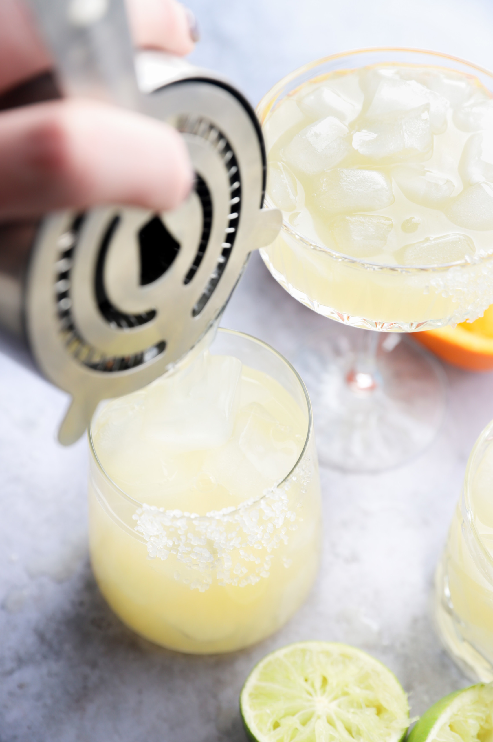 Pouring a tequila cocktail into a rimmed glass picture