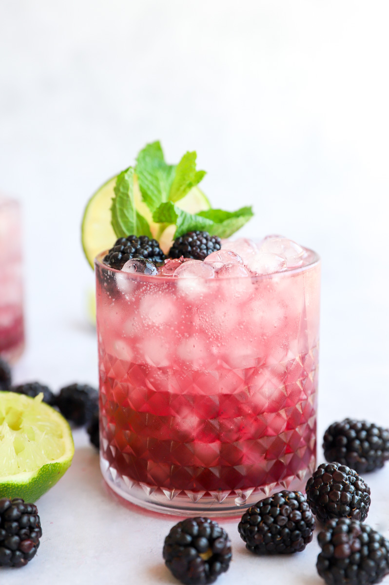 Side image of cocktail with blackberries and mint