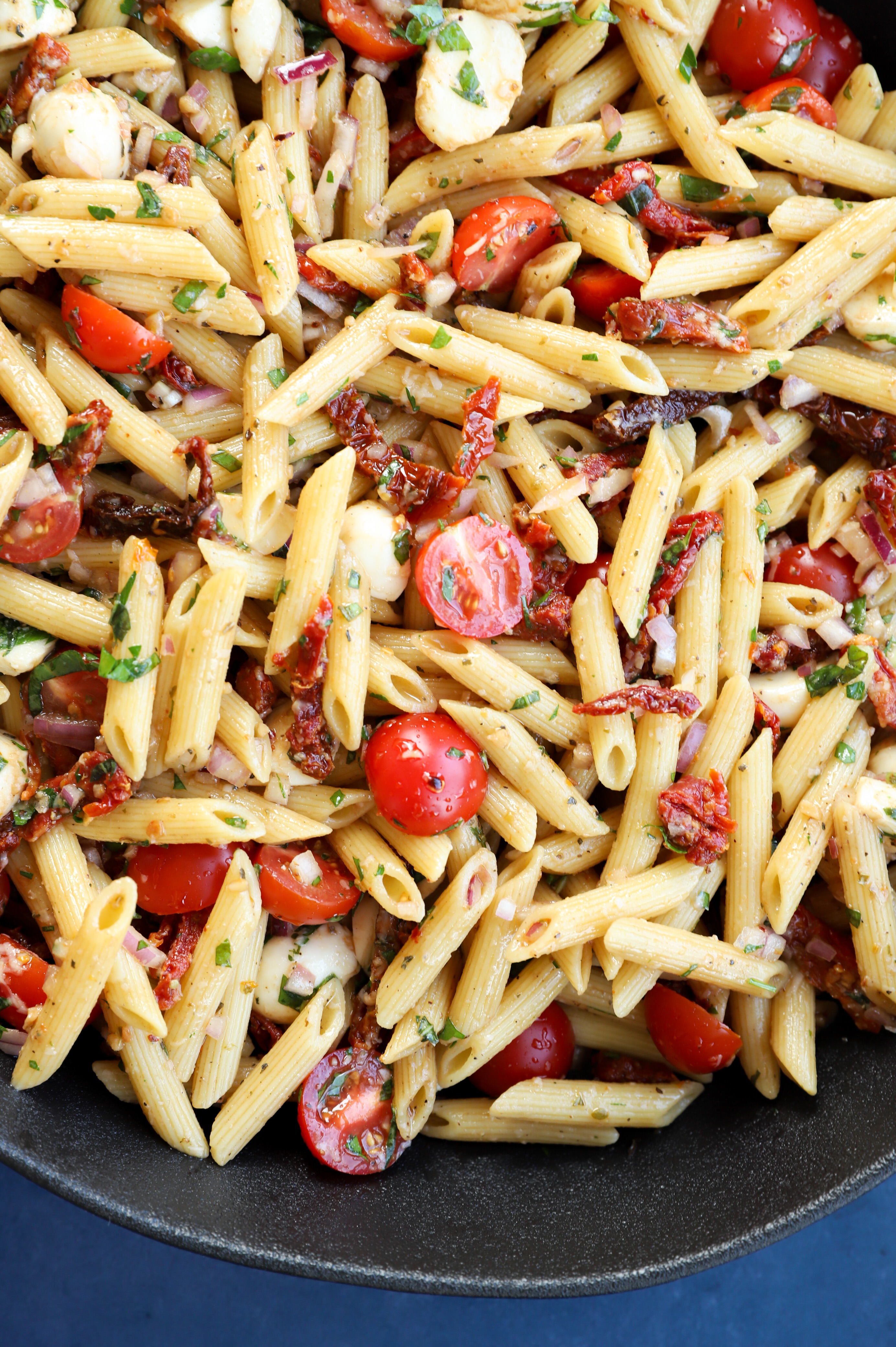 Image of a bowl of penne with vegetables and dressing