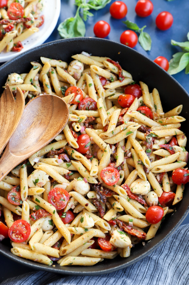 Overhead image of pasta in a bowl with serving spoons image