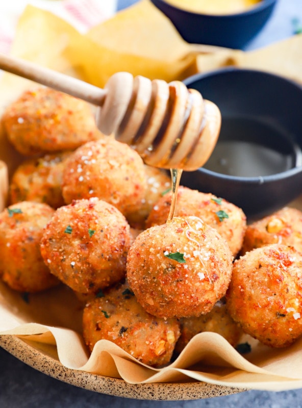 drizzling honey on cheese corn balls image