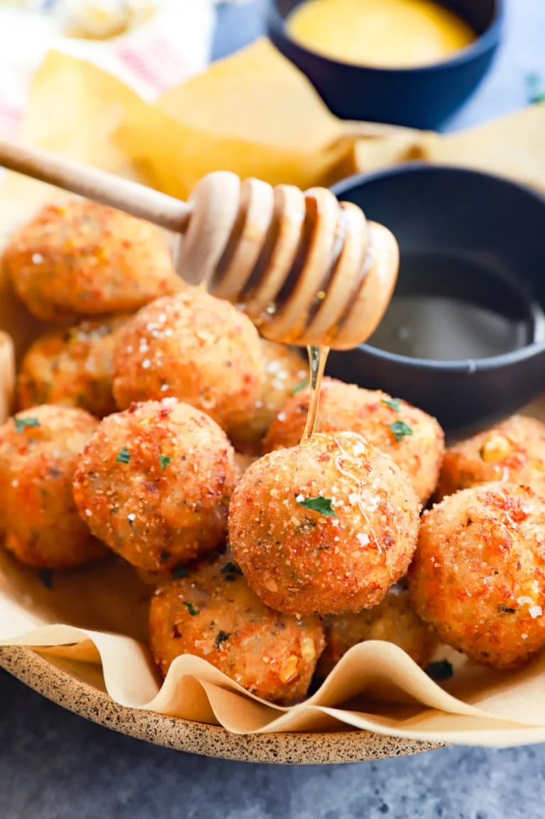 drizzling honey on cheese corn balls image