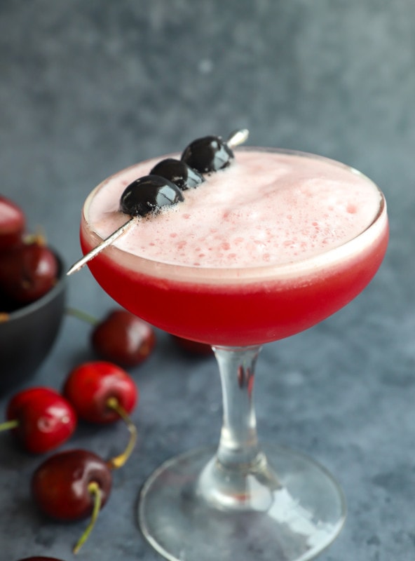 Image of frothy cocktail with cherries on top