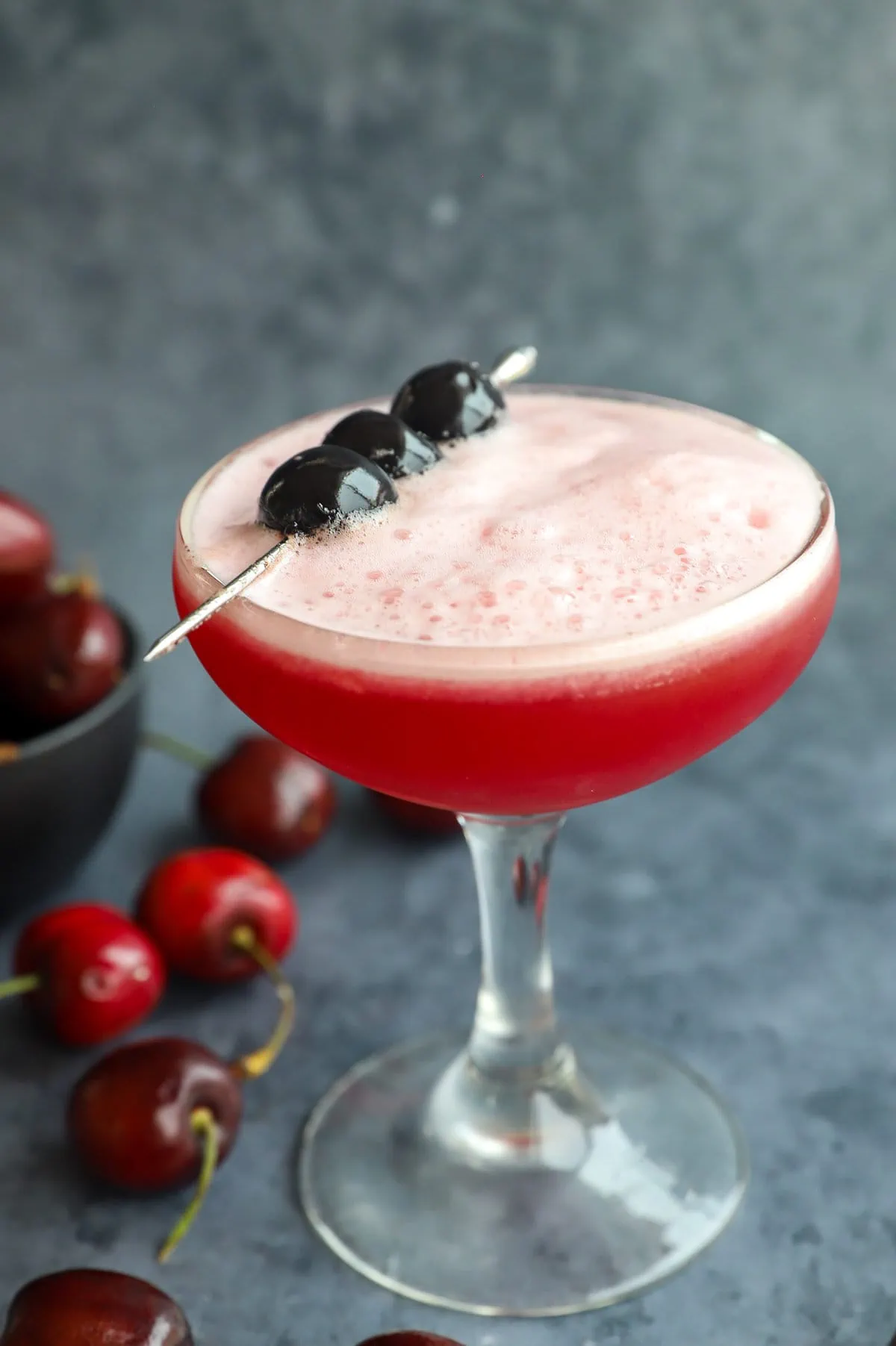 Image of frothy cocktail with cherries on top