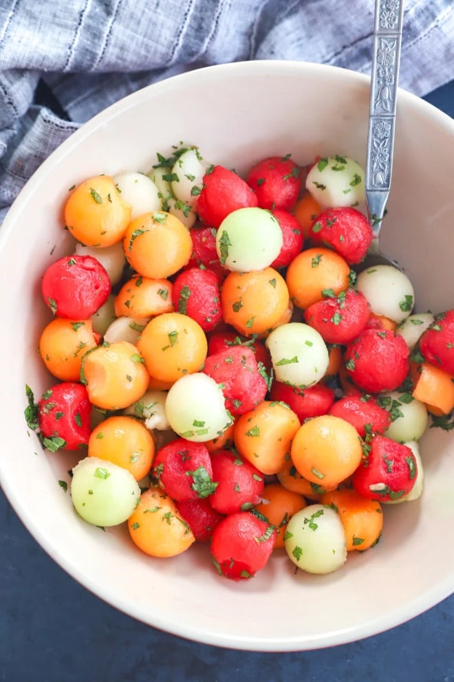 Overhead image of making a fruit salad with dressing