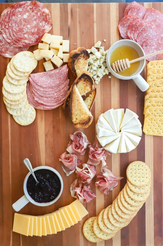 putting together an appetizer spread with meat and cheese image