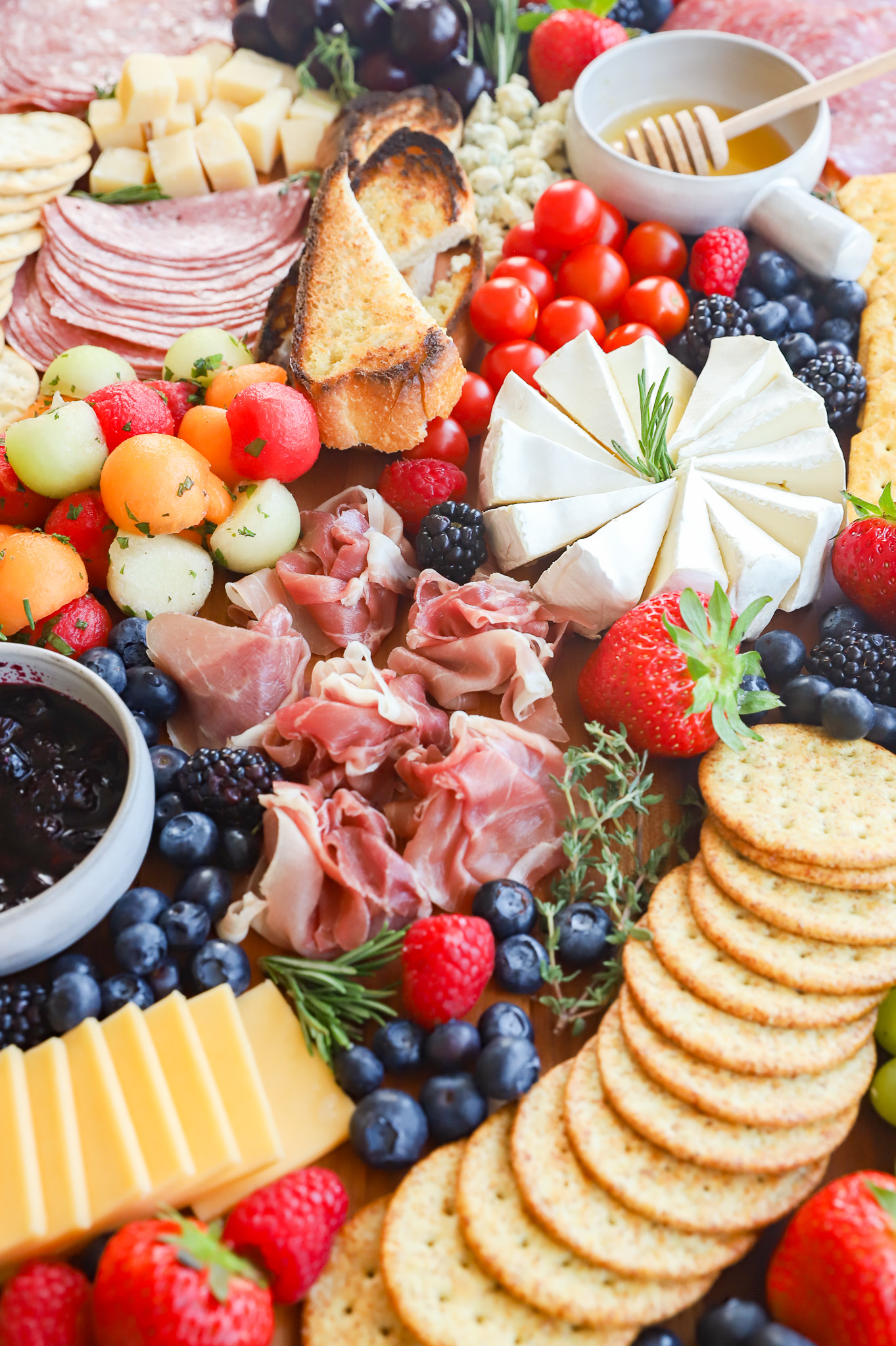 Picture of brie, herbs, fruits, and meats