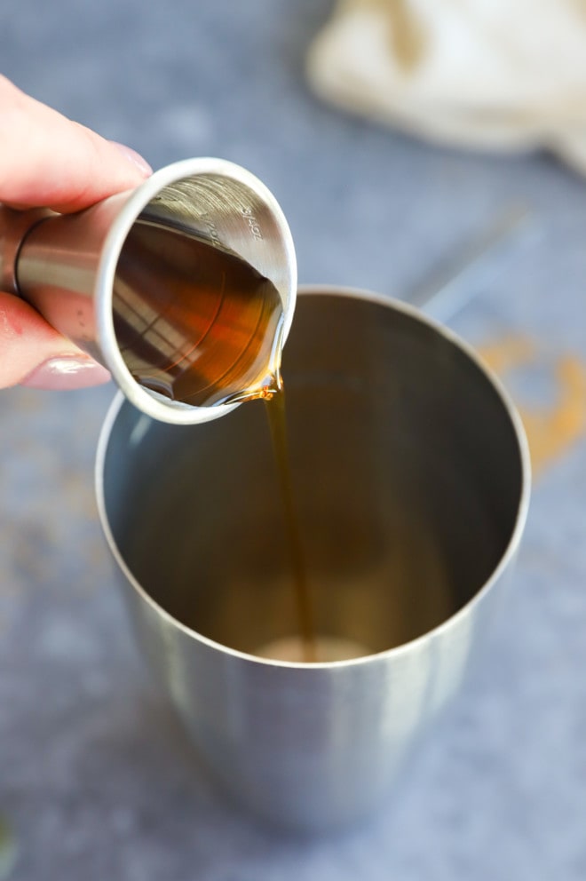 Pouring liquid sweetener into a cocktail shaker