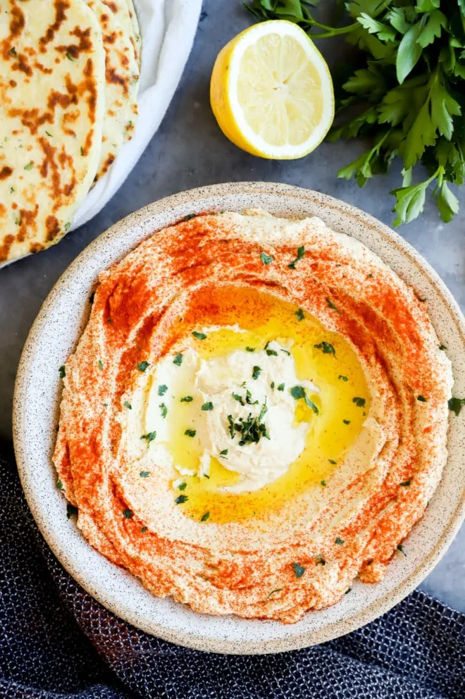 Bowl of savory dip made from chickpeas with bread on the side