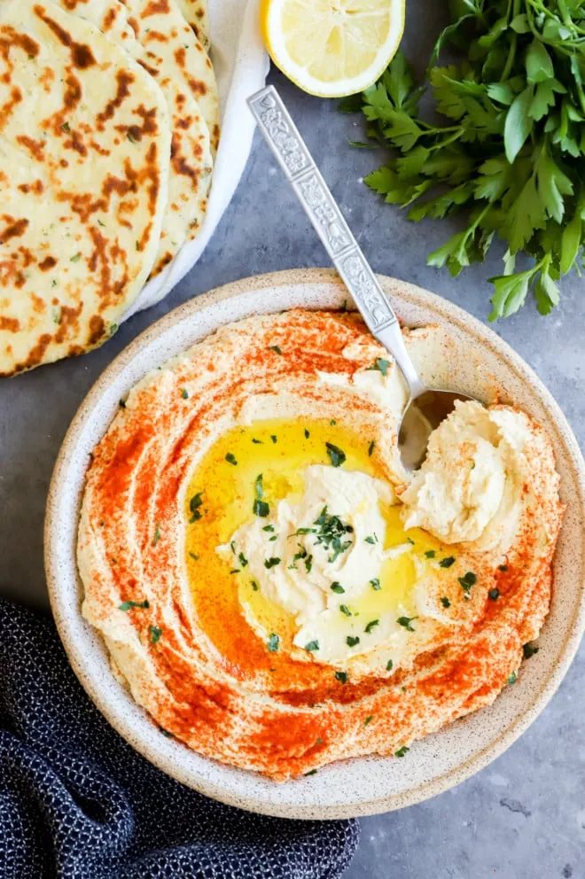 Image of creamy hummus in a bowl with a spoon
