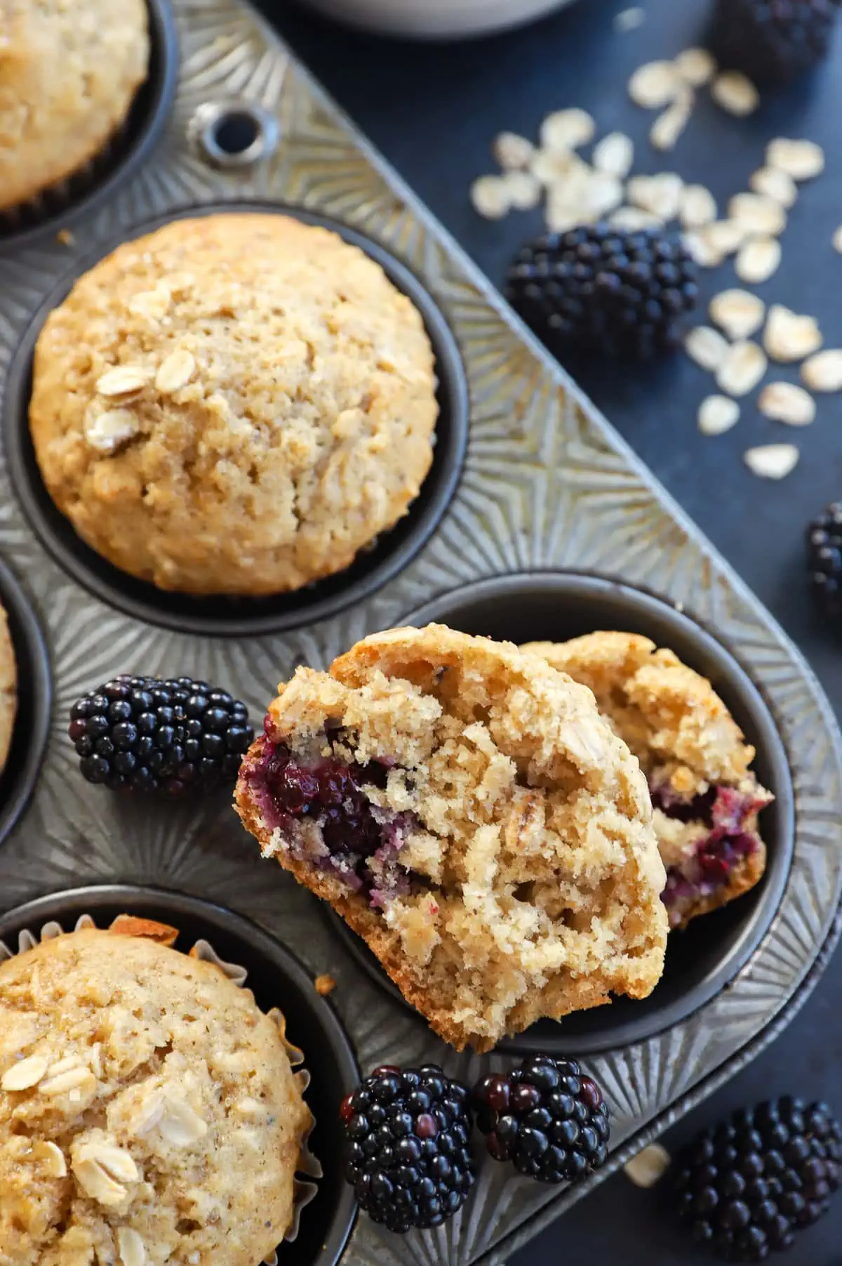 half of a muffin in a muffin tin with fresh berries and oats
