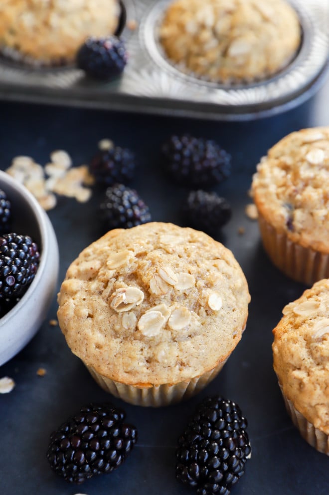 Oatmeal blackberry muffins in liners with fresh fruit