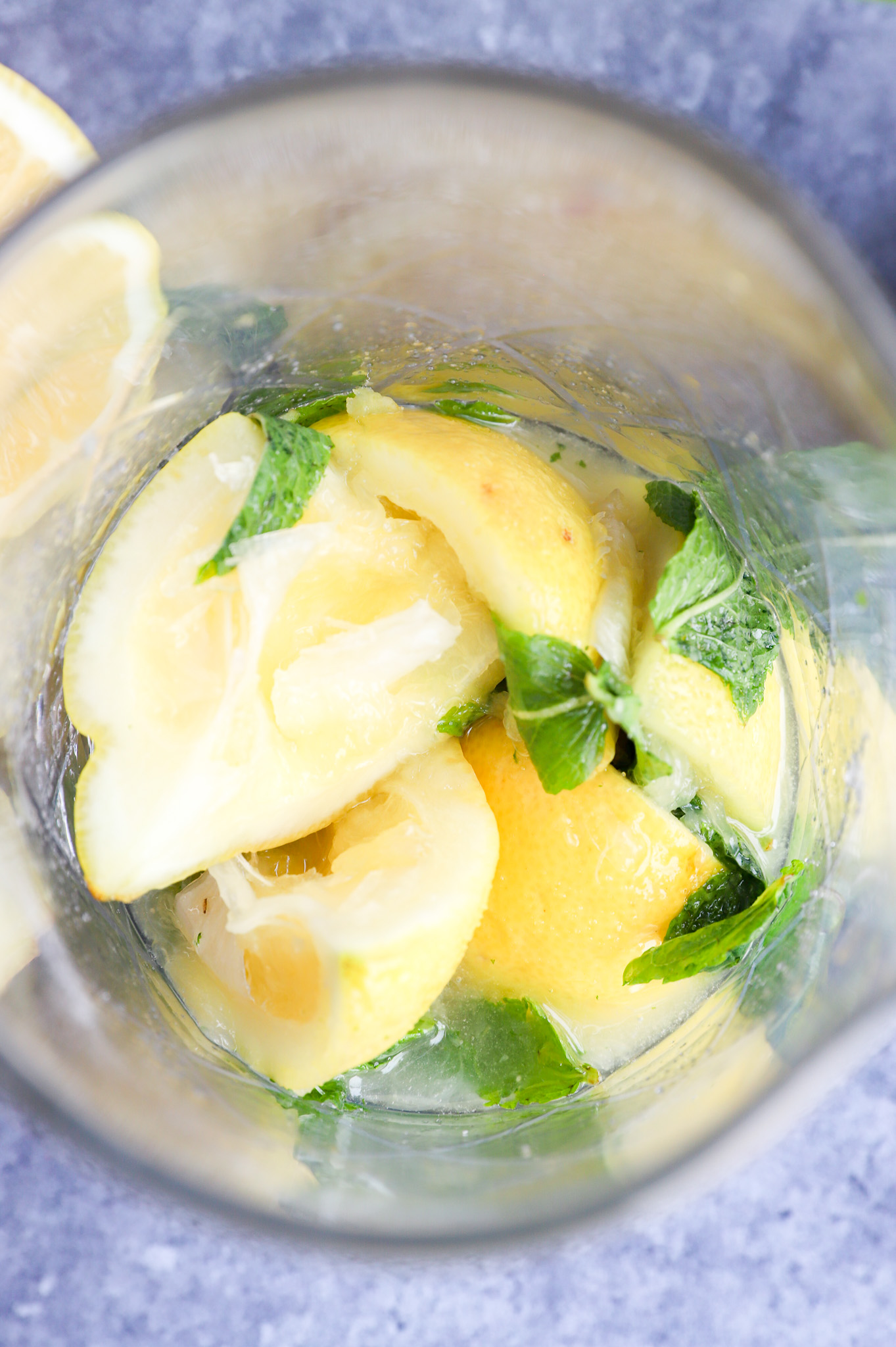 Muddled citrus and mint leaves in a cocktail glass photo