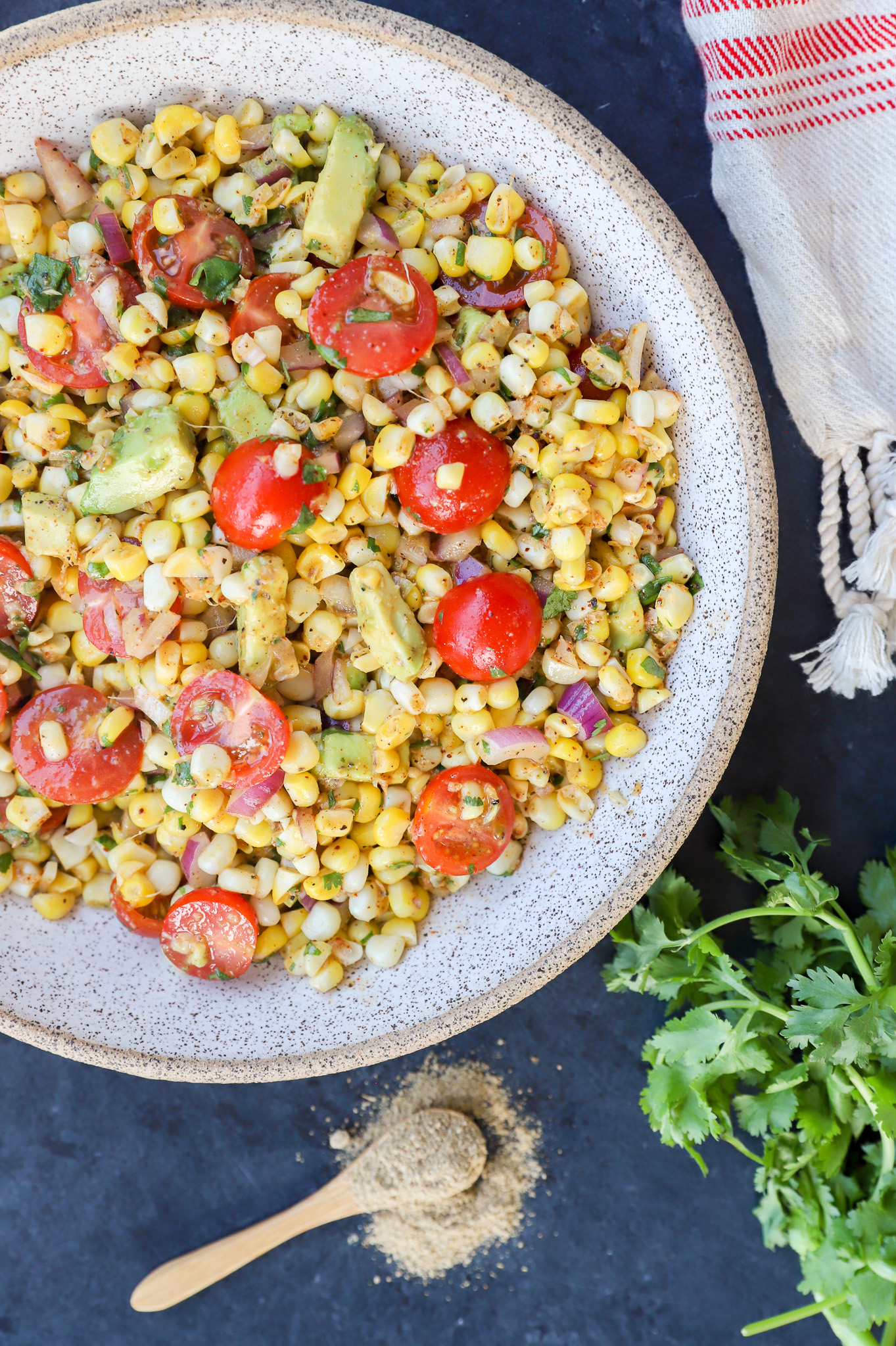 Overhead image of a salad with tomatoes, avocado, and chaat