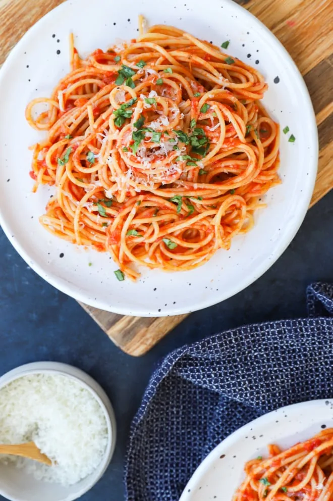 Plate of spaghetti with tomato sauce with fresh basil and cheese