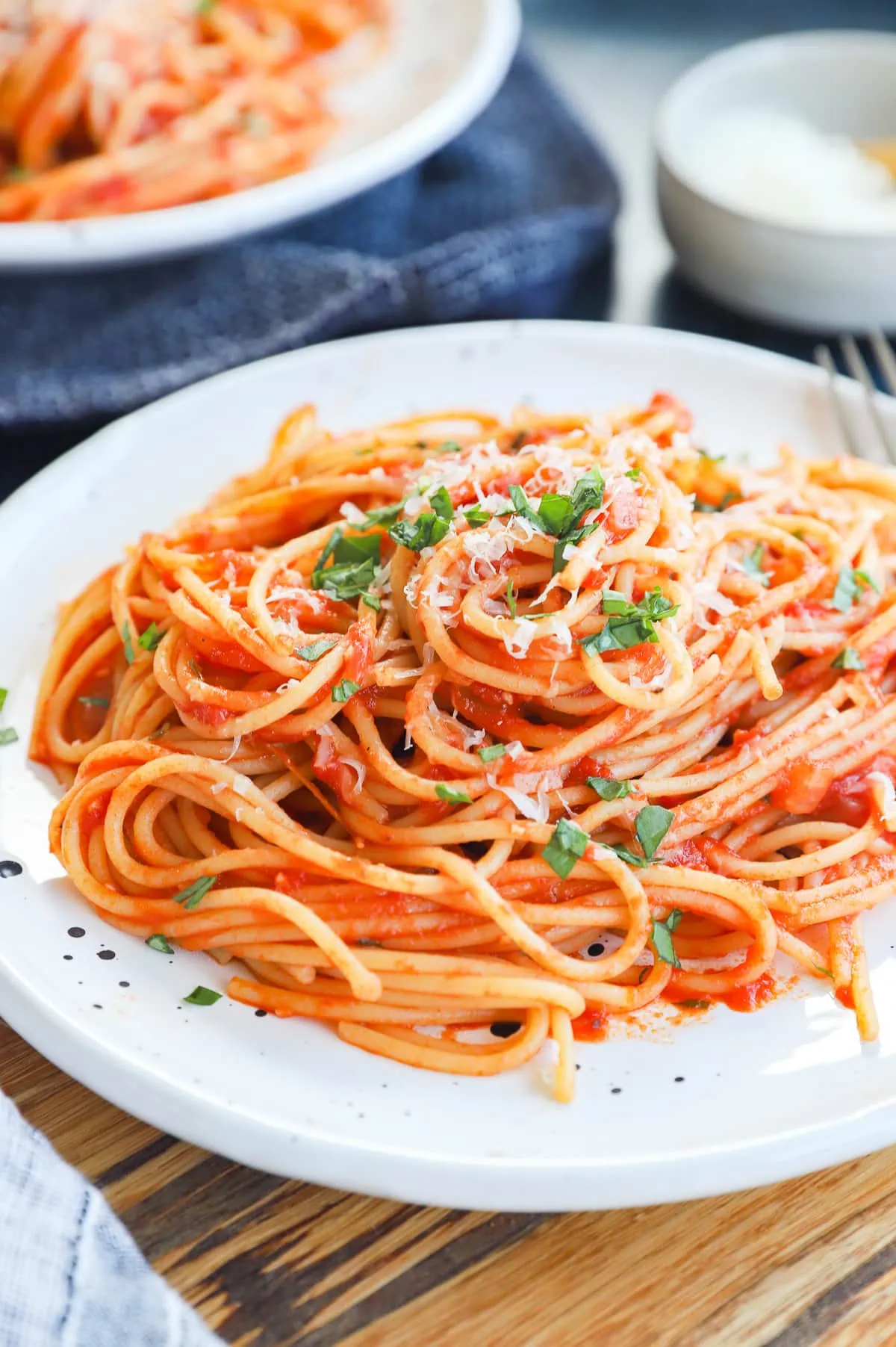 Pasta napolitana on a plate with fresh basil and parmesan