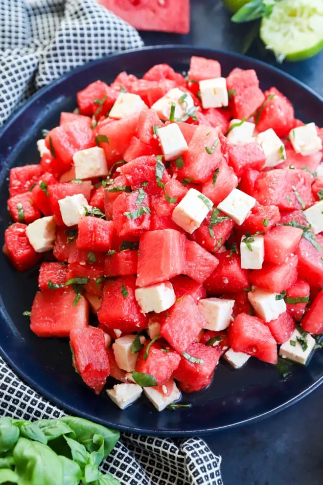 Watermelon cubes mixed with feta cubes and basil image
