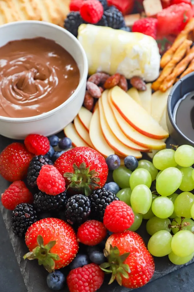 Fresh berries, grapes, apples and nutella on a snack tray
