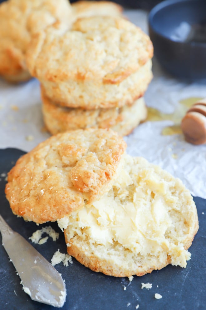 A biscuit spread with butter on a plate