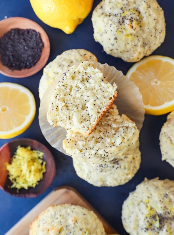 Lemon poppy seed muffins in a pile with liners