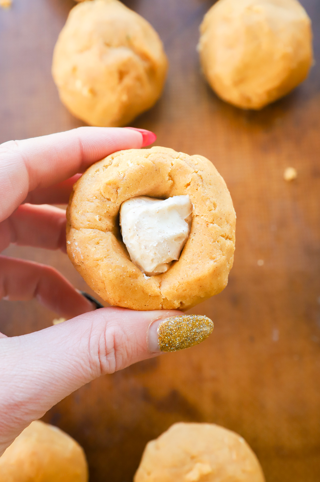 stuffing a pumpkin cookie dough ball with a cheesecake ball