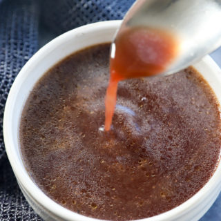 spooning au jus into a bowl