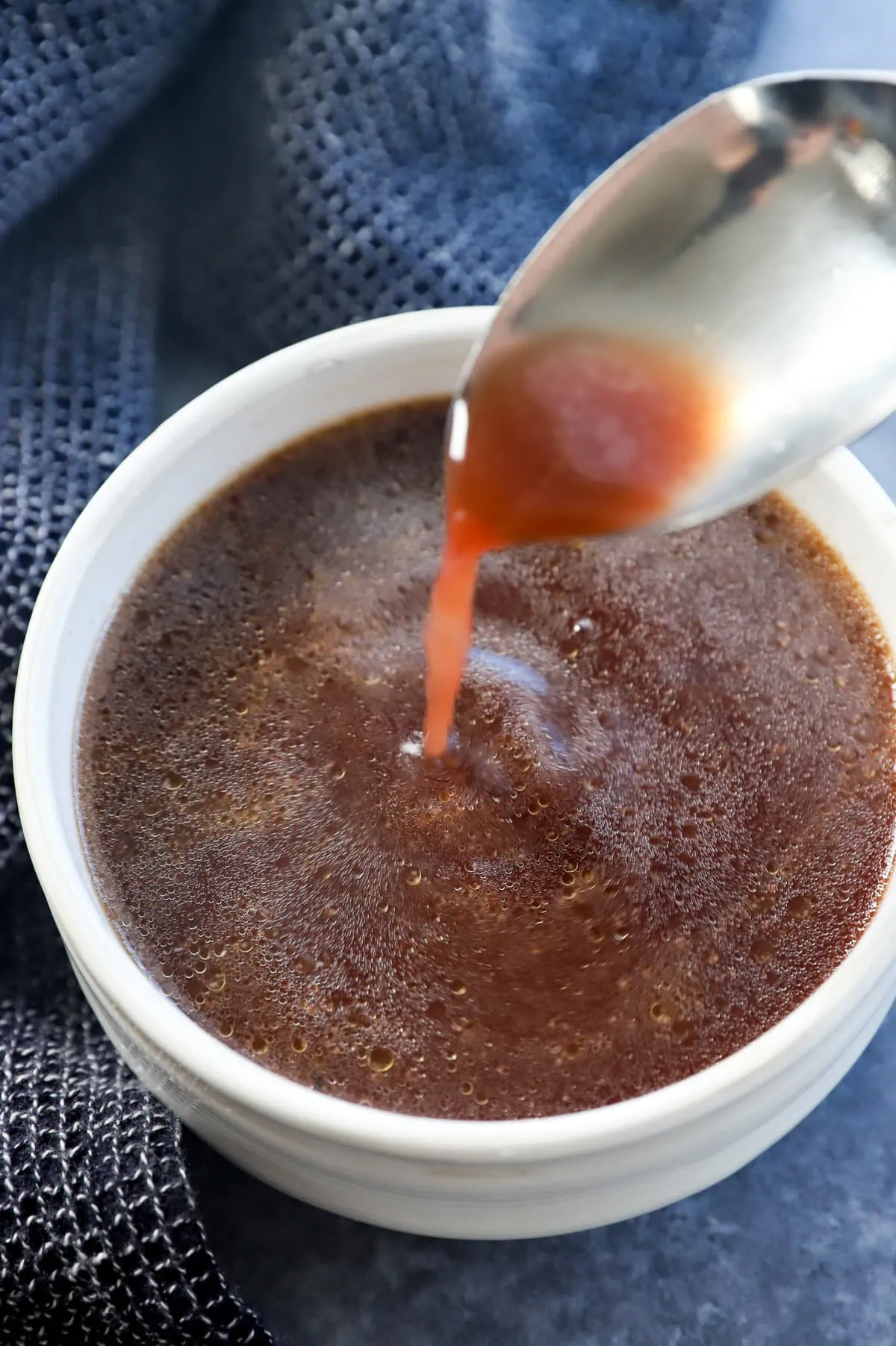 spooning au jus into a bowl