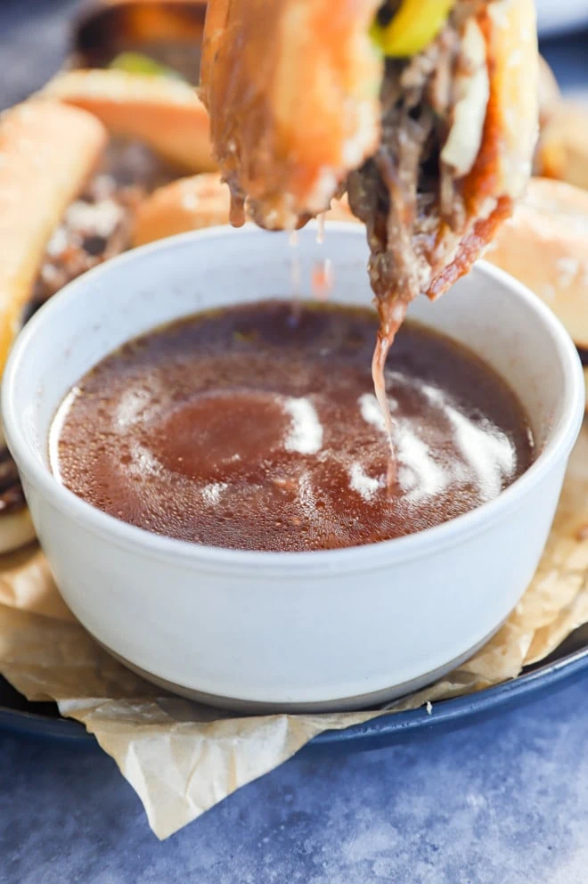 Dipping a sandwich into a bowl of au jus