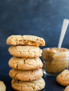 pile of chewy peanut butter cookies and peanut butter in the back