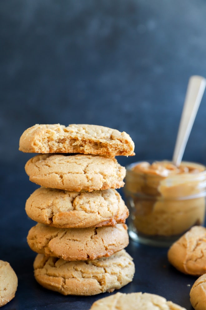 pile of chewy peanut butter cookies and peanut butter in the back