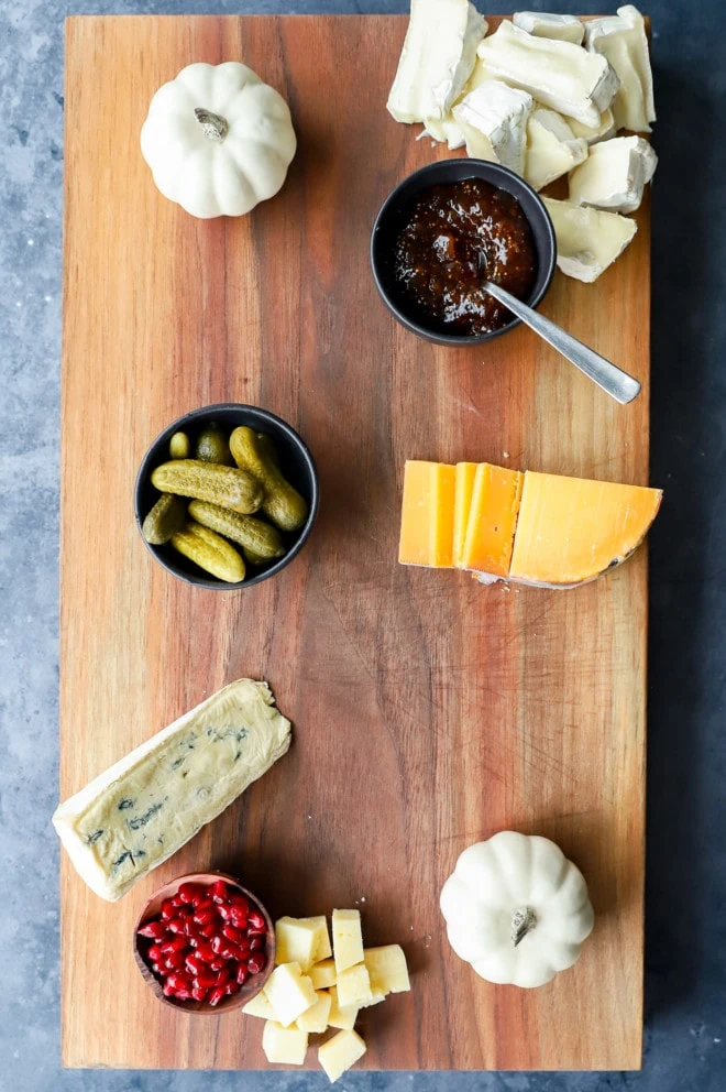 cheeses and dips on wood with pumpkins
