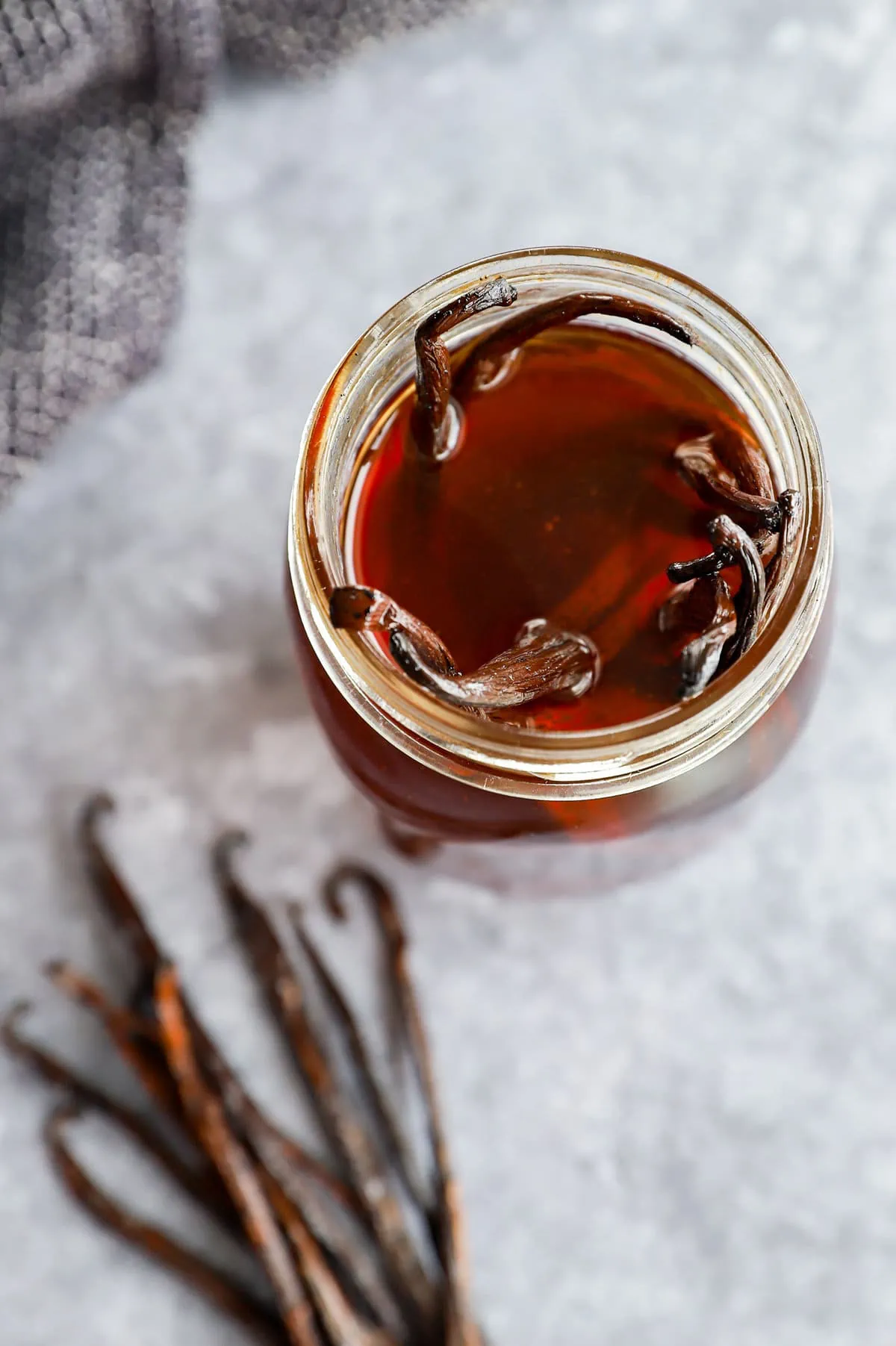 making homemade vanilla extract in a mason jar with whole vanilla beans