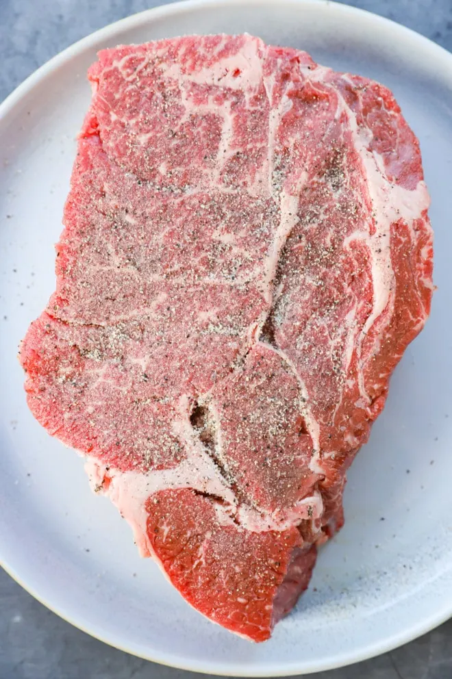 chuck roast seasoned with salt and pepper on a plate