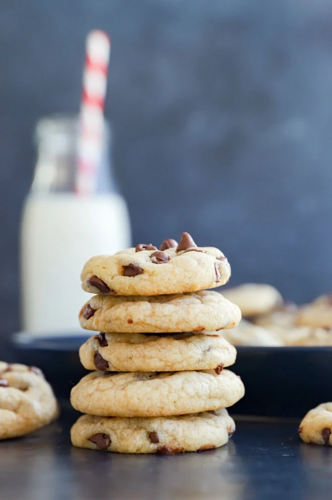 Stack of miniature cookies with milk in a bottle and straw
