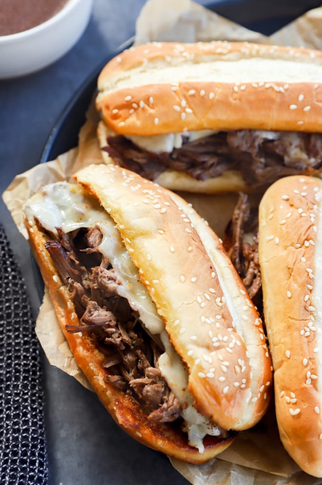 Beef dip sandwiches on a platter with parchment paper