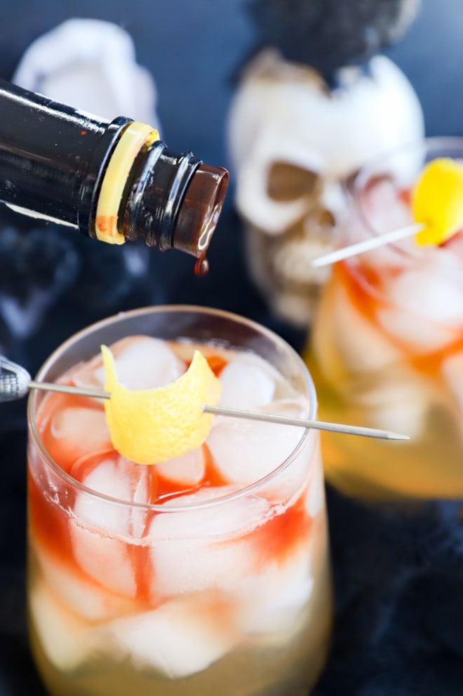 Adding angostura bitters to a spooky drink