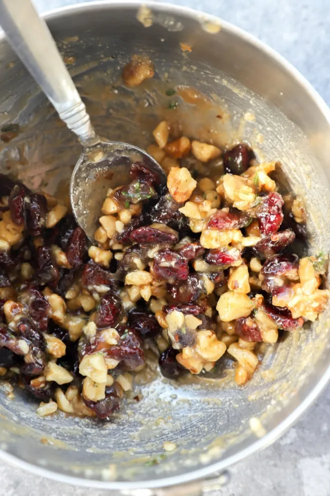 Mixture of butter, cranberries, walnuts, and sugar in a bowl