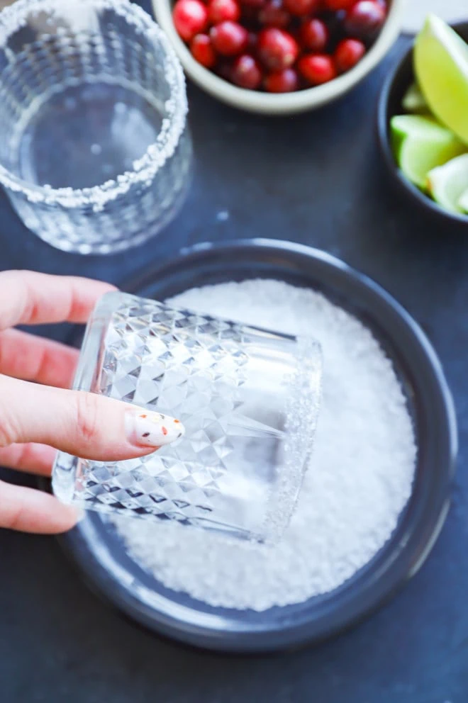 Rolling the rim of a cocktail glass in salt