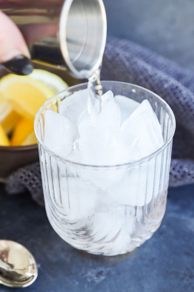 pouring gin into a cocktail glass