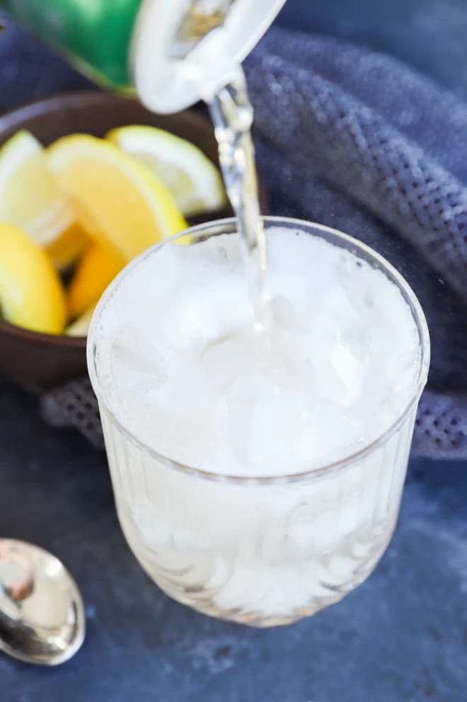 pouring ginger ale into a cocktail glass