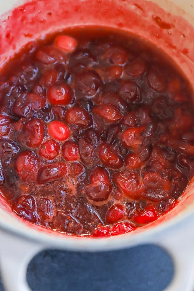 cranberries in a pot with orange and sugar