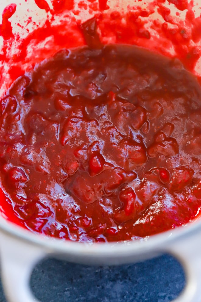 making cranberry jam in a saucepan