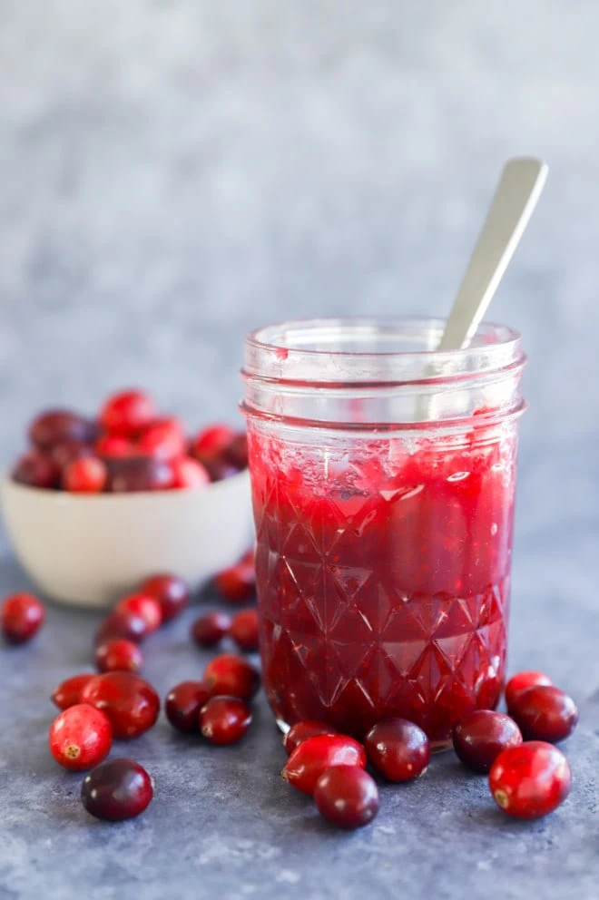 cranberry jam in a mason jar with a spoon