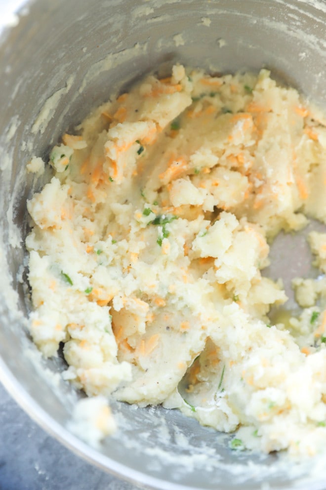 Making mashed potato fritters mixture in bowl